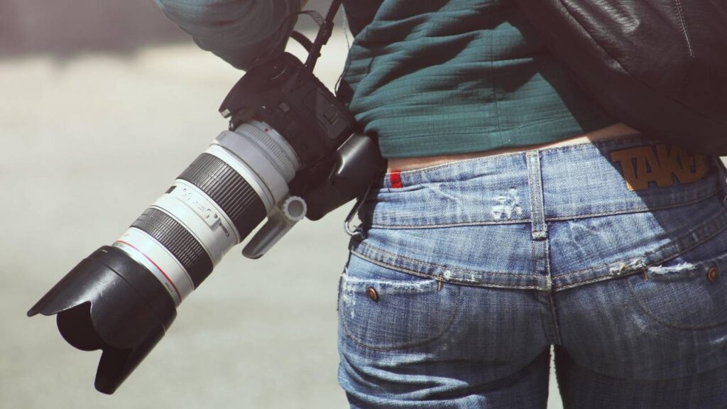 A photo of a woman with a large camera on her waist